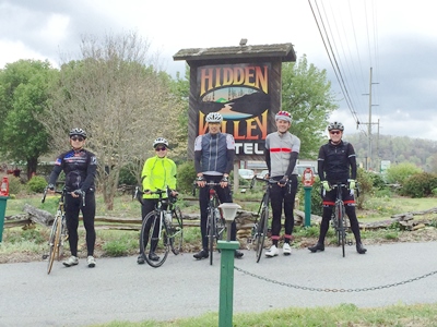 Photo of a group of guests with thier bikes near the Hidden Valley Motel sign